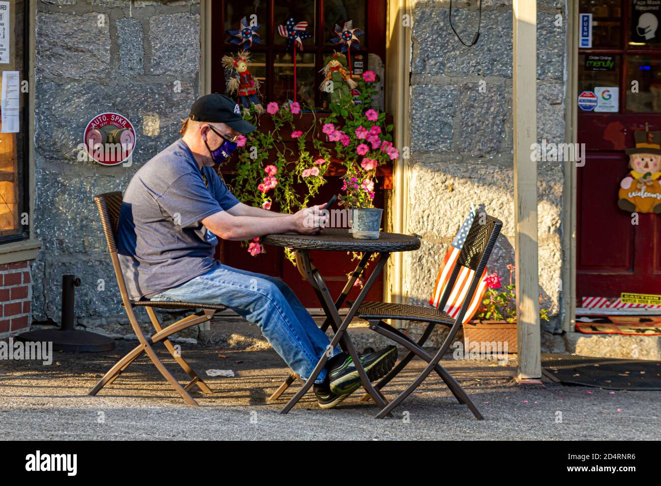 Ellicott City, MD, USA 10/07/2020: A causa della pandemia COVID-19, i clienti dei ristoranti preferiscono sedersi all'aperto e con le loro maschere sopra. Un uomo caucasico Foto Stock
