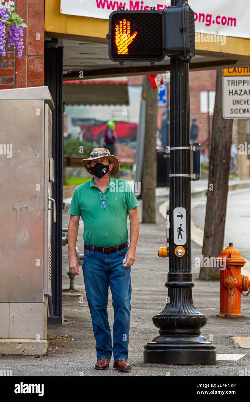 Ellicott City, MD, USA 10/07/2020: Un uomo caucasico di mezza età che indossa cappello Akubra, jeans e stivali da cowboy in pelle sta aspettando al semaforo. Lo è Foto Stock