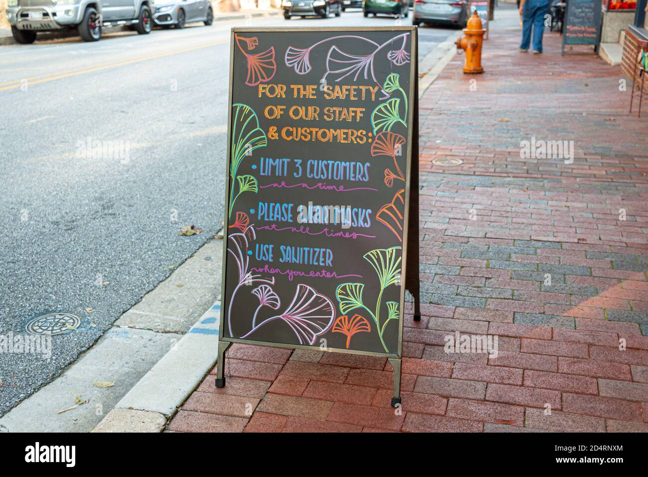Un panino nero in stile lavagna davanti a un ristorante nella storica Ellicott City. La scheda ha delle norme per i clienti come maschere facciali. Foto Stock