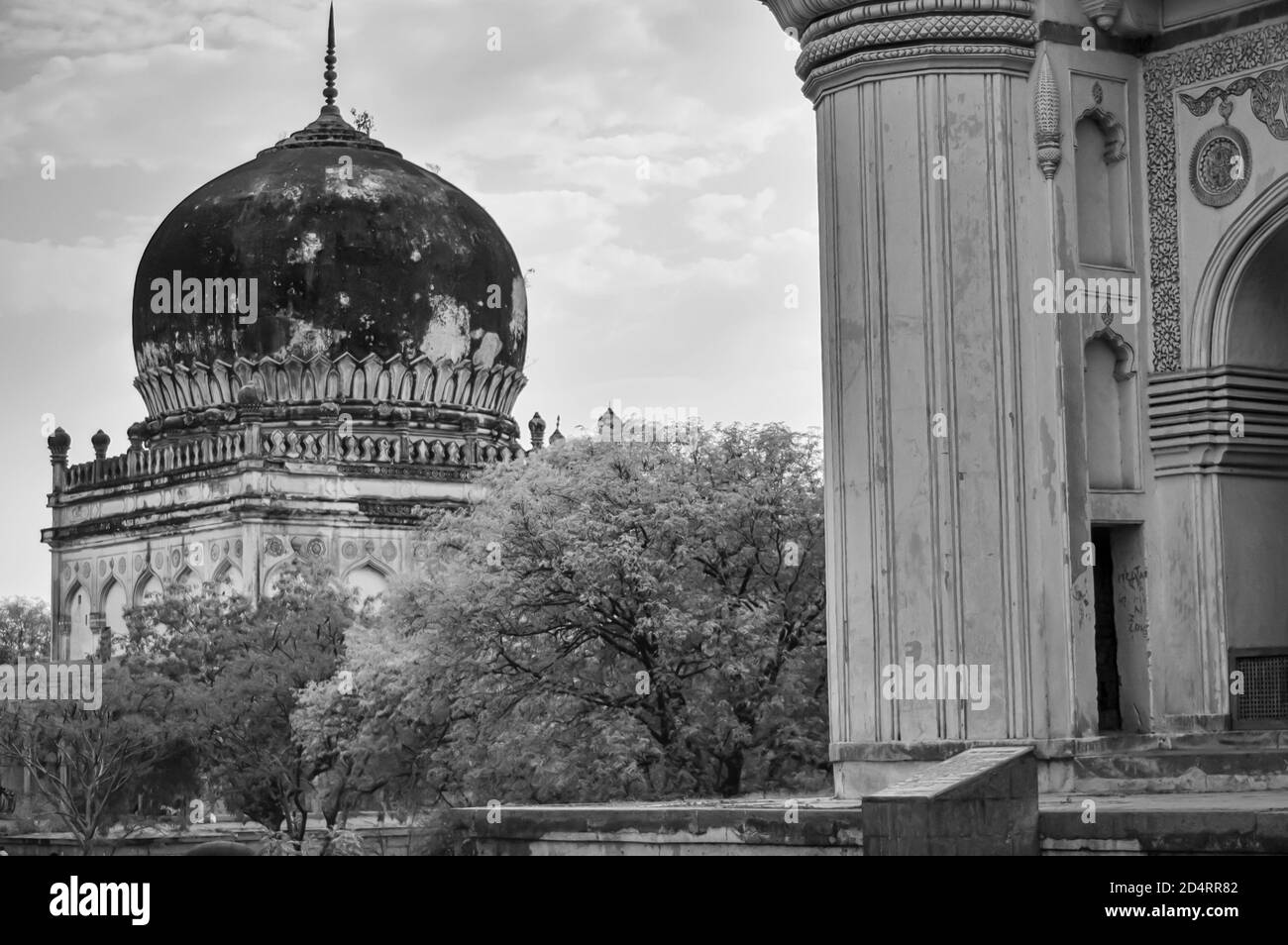 Immagine in bianco e nero di una sezione della Grande Moschea e di un mausoleo nel complesso delle Tombe Qutb Shahi situato a Ibrahim Bagh a Hyderabad, India. Foto Stock