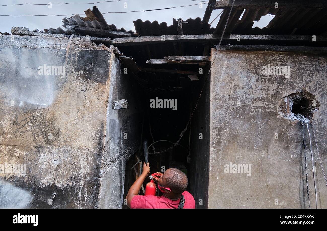 Una vittima di un incidente d'incendio utilizza un estintore dopo che un camion a gas è esploso nella capitale commerciale nigeriana di Lagos l'8 ottobre 2020. Foto Stock