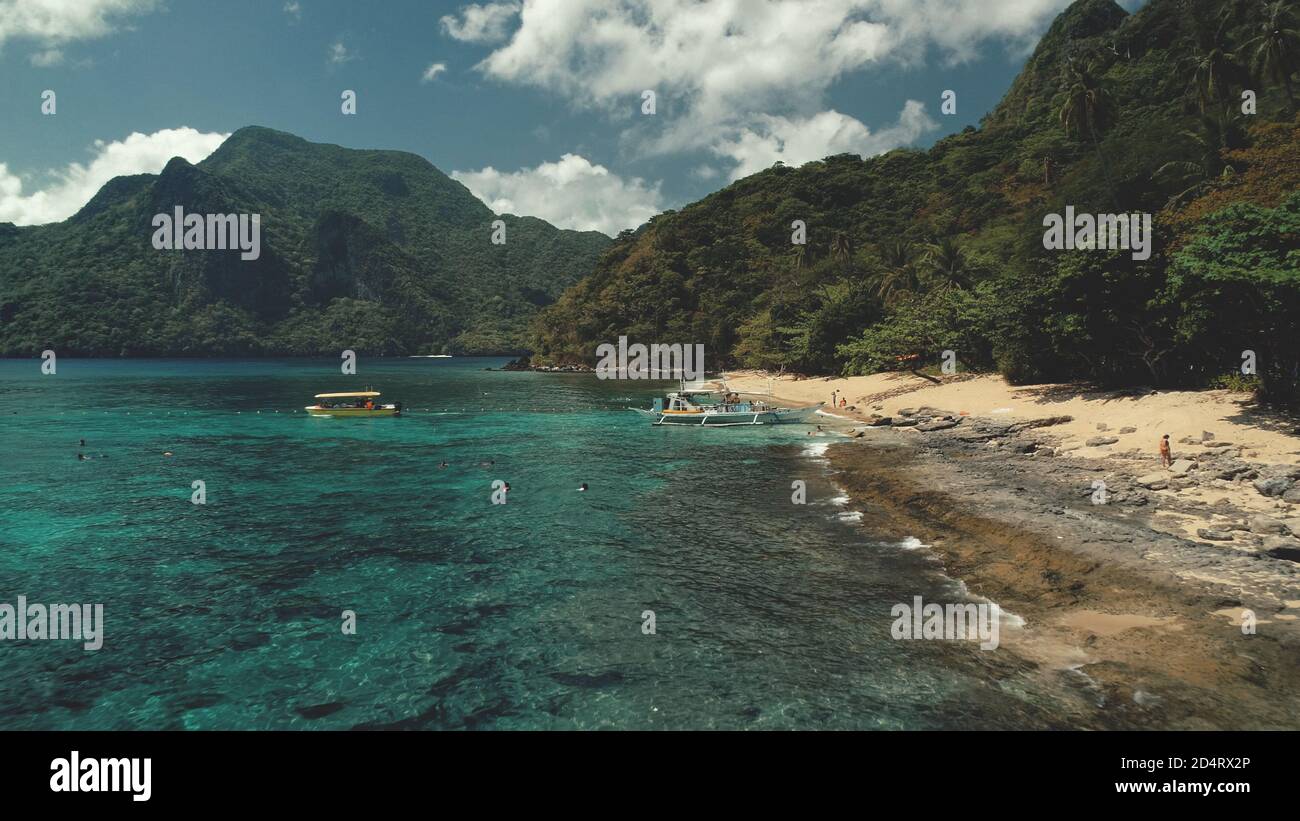 Vista aerea della crociera per passeggeri dell'oceano delle Filippine. Persone in barca, nave vela a El Nido Island da mare baia. I turisti riposano sulla spiaggia di sabbia a riva acqua tropicale. Paesaggio incredibile in un paradiso asiatico resort Foto Stock