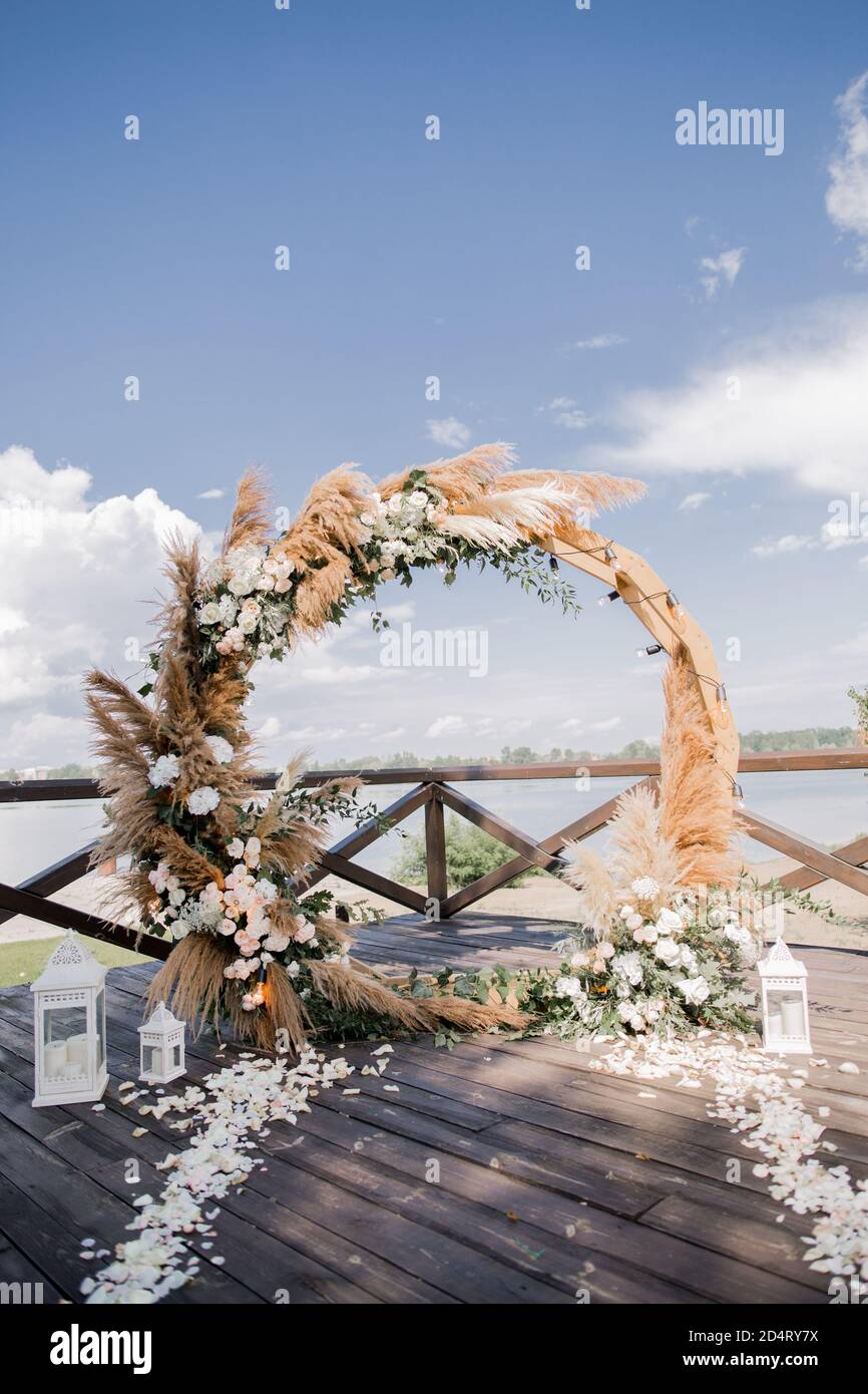 matrimonio arco rotondo in legno con fiori sul molo Foto stock - Alamy