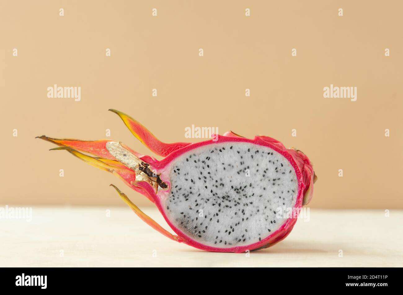 mezzo rosso succosa drago frutta pitaya con carne bianca su fondo beige pulito, tendenza al minimalismo alimentare, fuoco selettivo Foto Stock