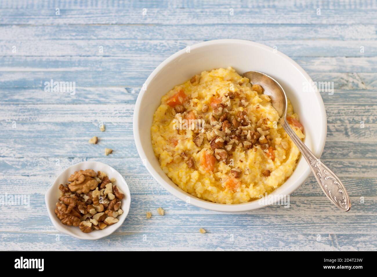 Porridge di mais con zucca, miele e noci su sfondo di legno blu Foto Stock