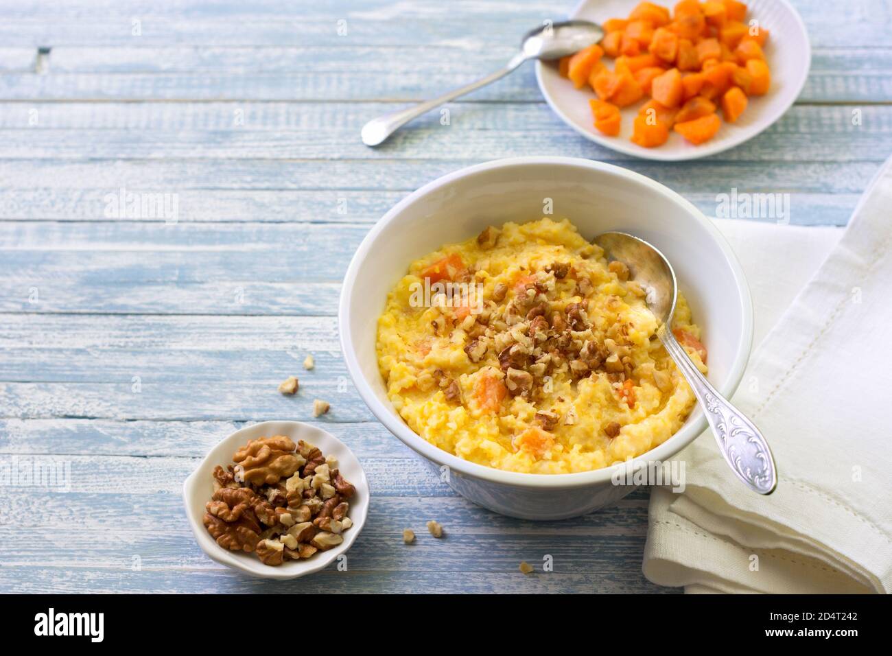 Porridge di mais con zucca, miele e noci su sfondo di legno blu Foto Stock