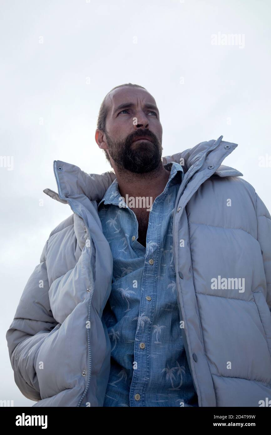 Uomo bearded in giacca Puffa contro cielo Foto Stock