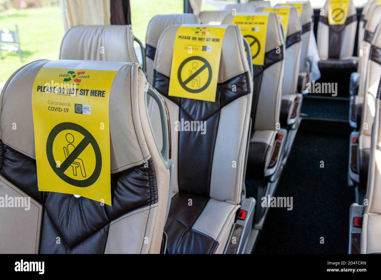 Fila di posti vuoti in autobus con cartelli gialli di distanziamento sociale a causa della pandemia di Covid 19 all'interno dell'autobus con Dublin Coach in Irlanda Europa Foto Stock