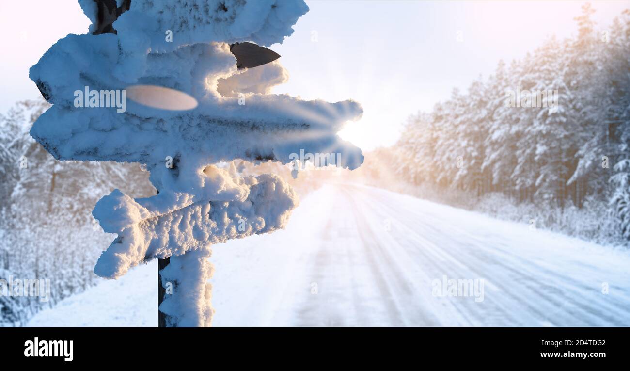 Cartelli coperti di neve con frecce in legno. Viaggio invernale Foto Stock