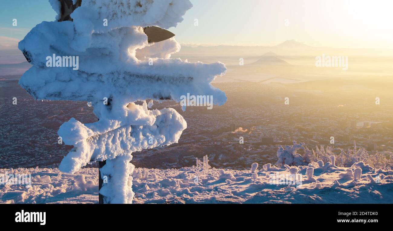Cartelli coperti di neve con frecce in legno. Viaggio invernale Foto Stock