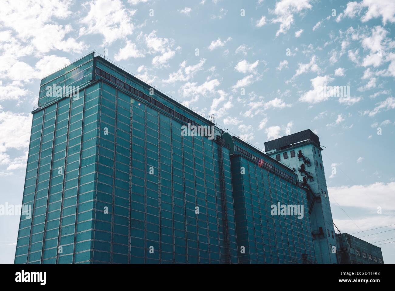 Parete gigante di un edificio di produzione a più piani. Pittoresca vecchia fabbrica di lavoro ristrutturata. Oggetto industriale invecchiato. Facciata di grande alto edificio manifatturiero Foto Stock