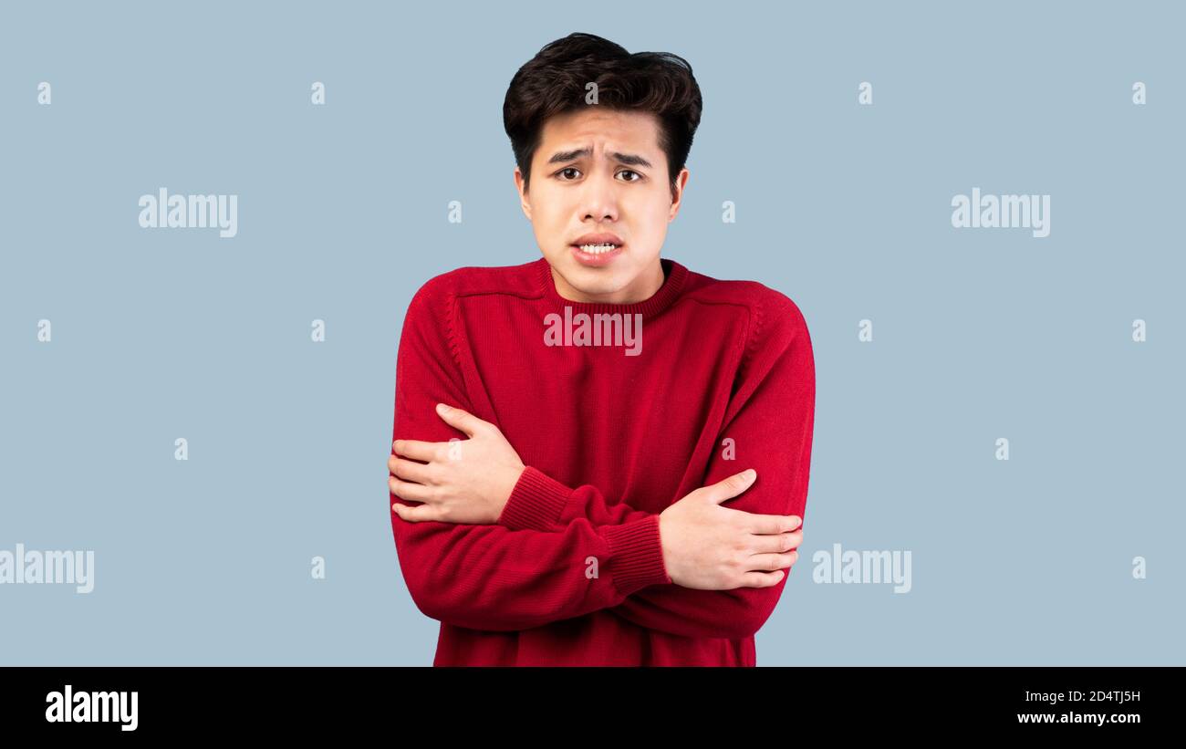 Ritratto di un ragazzo asiatico tremante, tremante e freddo Foto Stock