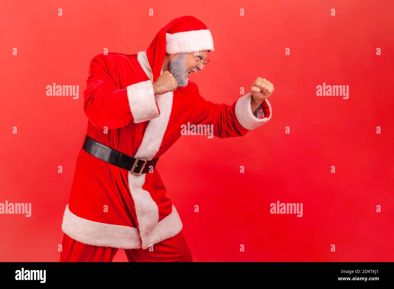 Ritratto in vista laterale di un uomo dal bearded grigio aggressivo che tiene i pugni in su, lotta con i competitori, fingendo di essere babbo natale, spirito di lotta o Foto Stock