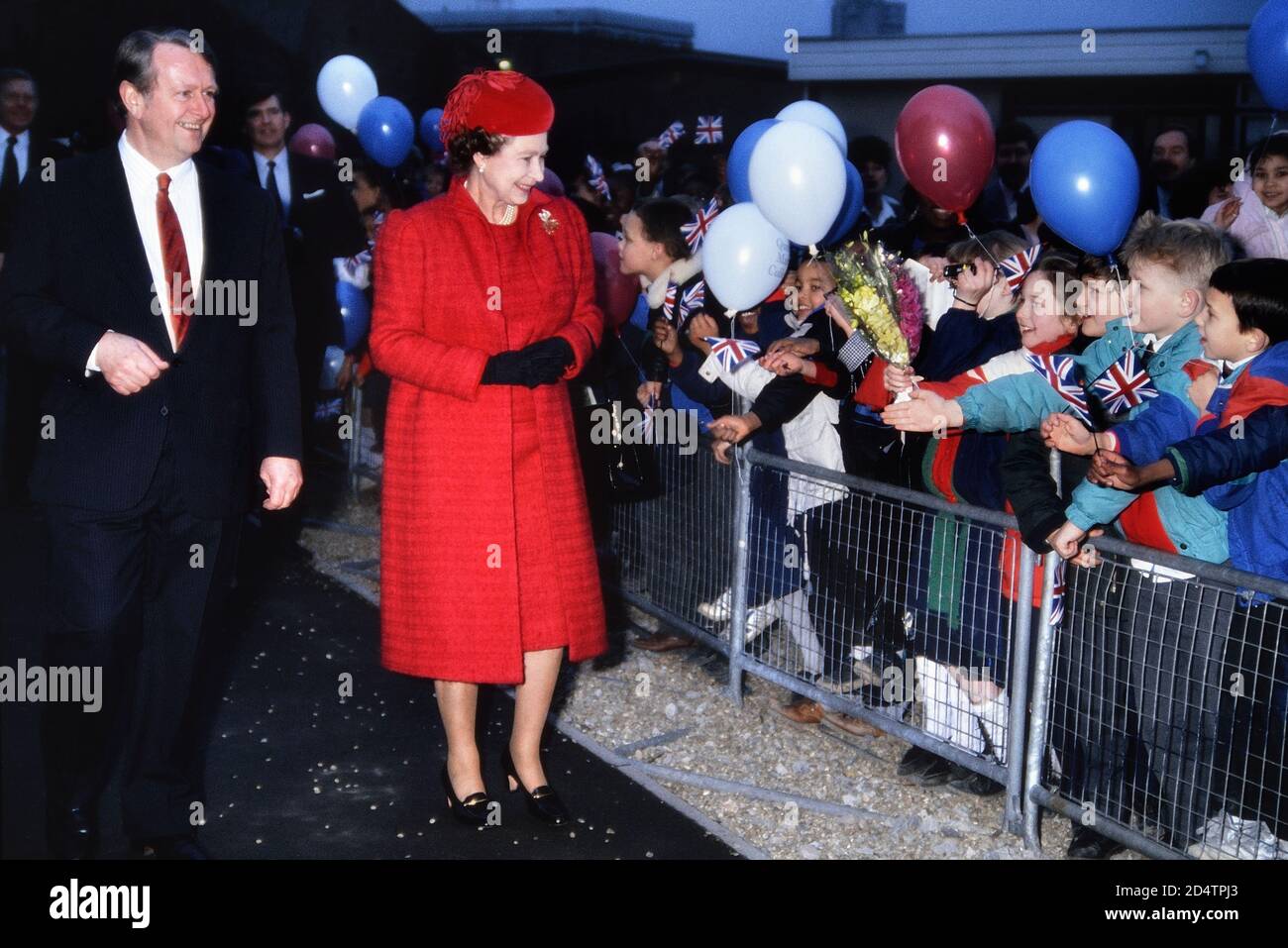 Una sorridente regina Elisabetta II circondata da bambini felici ed eccitati all'apertura della nuova biblioteca del Queen Mary College. Londra, Inghilterra, Regno Unito. Circa1988 Foto Stock