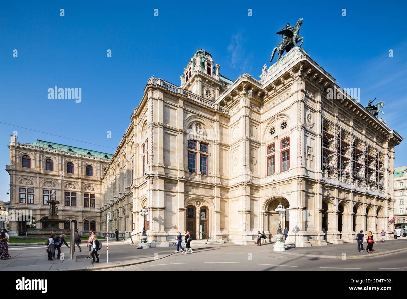 VIENNA - 5 MAGGIO: Vista dell'Opera di Stato di Vienna (Wiener Staatsoper) con persone e biciclette che passano il 5 maggio 2018. Foto Stock