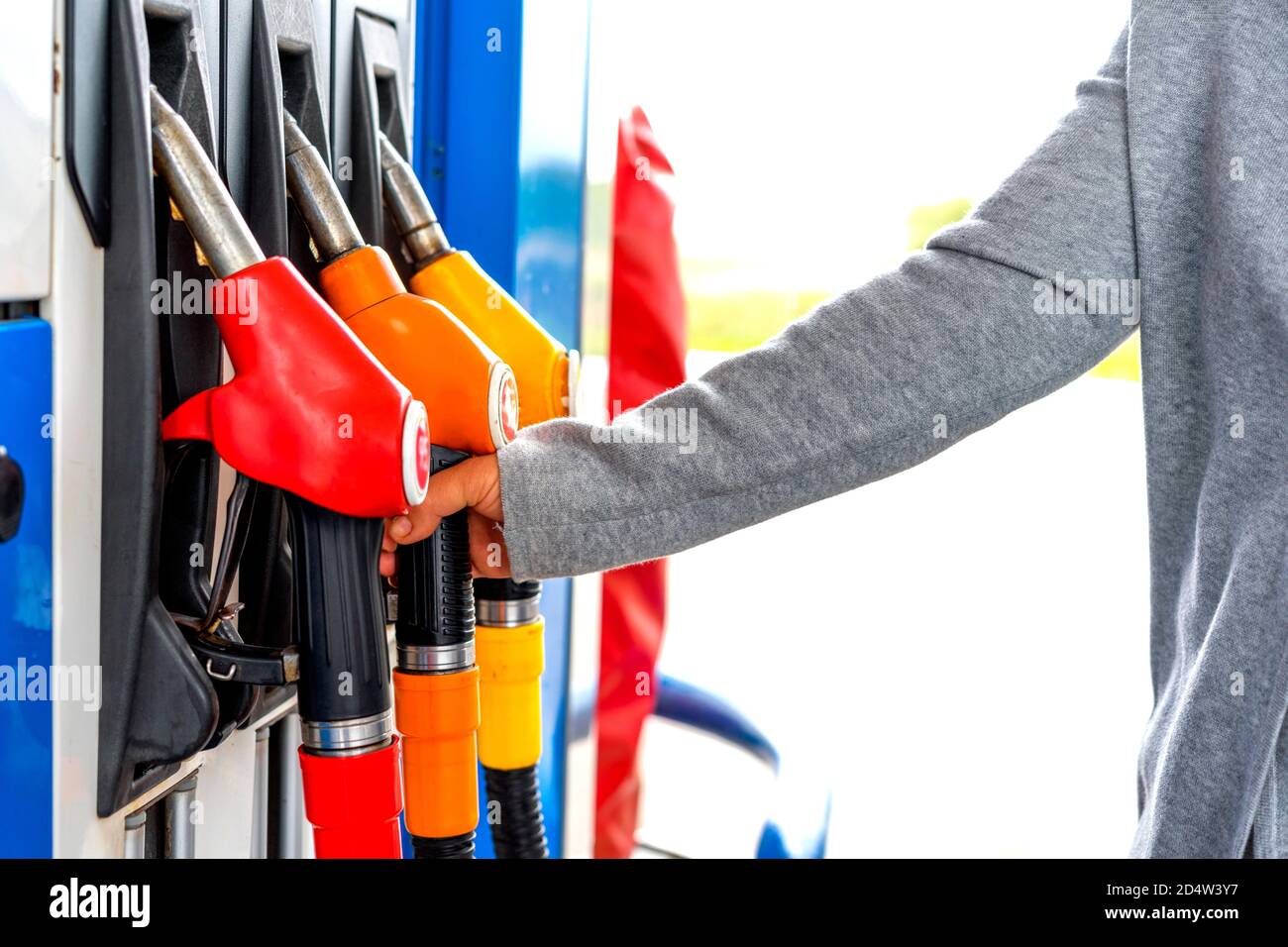Primo piano di una mano di una donna utilizzando un ugello carburante in una stazione di servizio. Stazione di servizio. Stazione di riempimento. Benzina. Benzina. Foto Stock