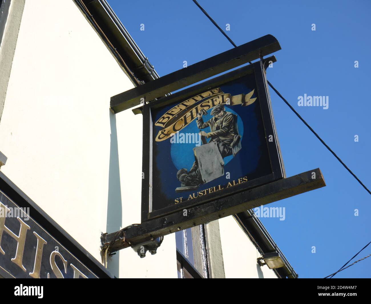 Il cartello del pub Bettle and Chisel a Delabole, in Cornovaglia, raffigura un lavoratore di ardesia che divide un'ardesia. Foto Stock