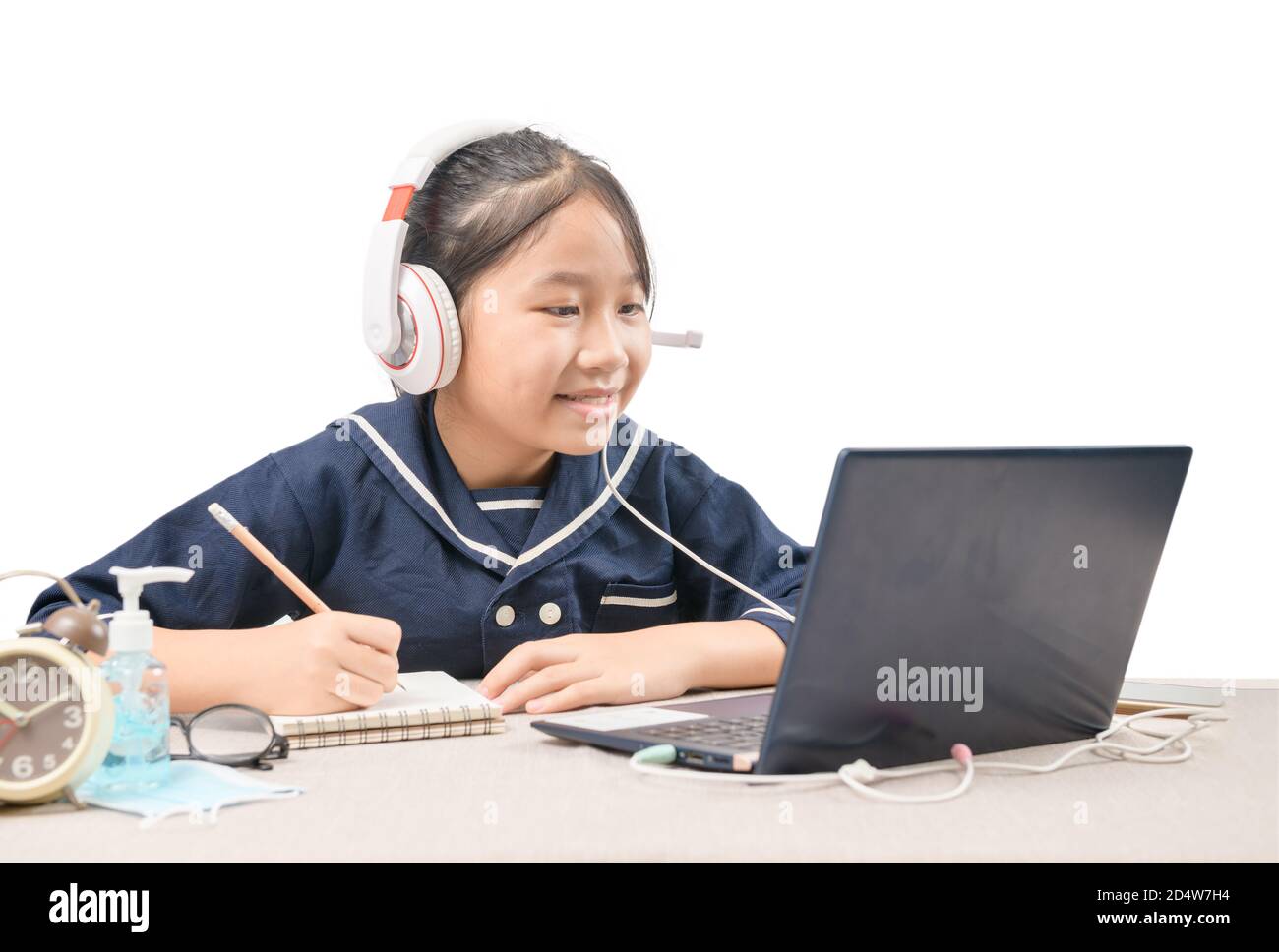 Felice ragazza cute che guarda i video in streaming online sul suo laptop a casa isolato su bianco. Homeschooling, apprendimento a distanza e nuovo concetto normale Foto Stock