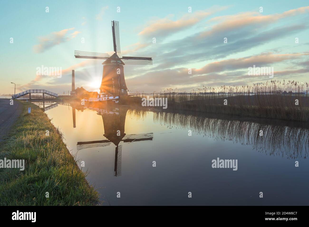 Il mulino a vento De Kaagmolen di fronte a un canale e barca, Olanda del Nord, Paesi Bassi Foto Stock