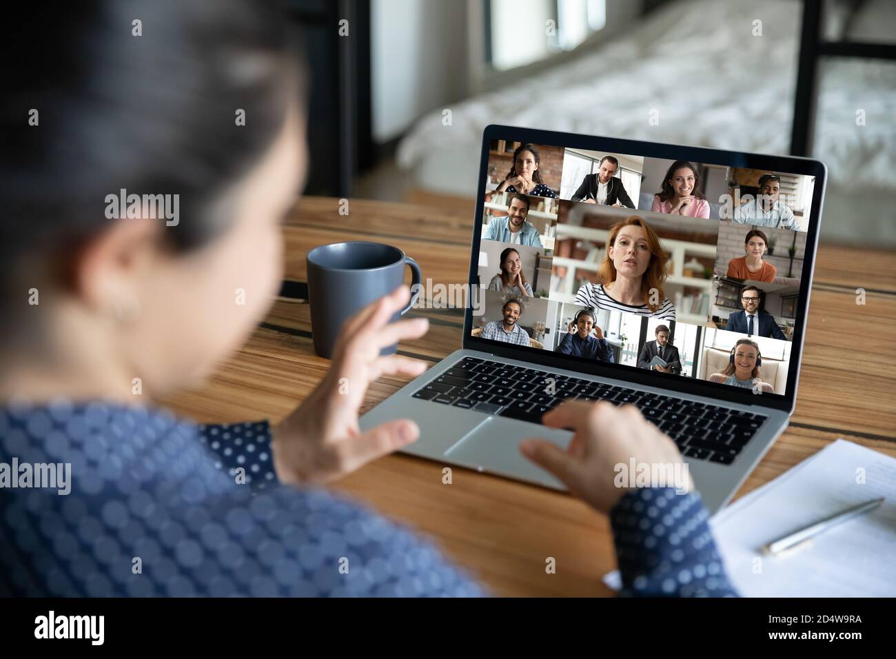 La donna parla in videochiamata di gruppo con diversi colleghi Foto Stock