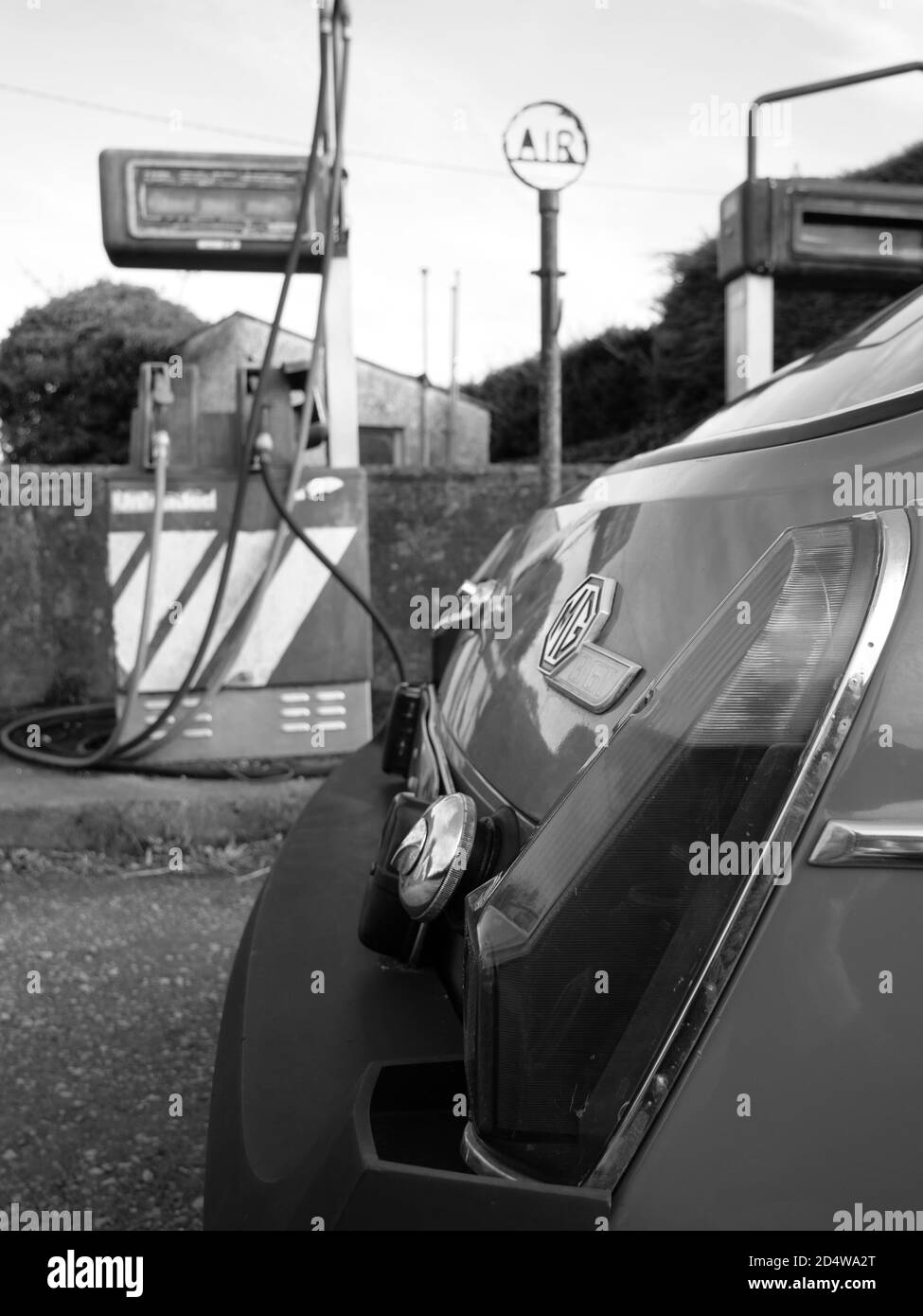 Un classico MGB GT si trova all'esterno di una stazione di rifornimento abbandonata Foto Stock