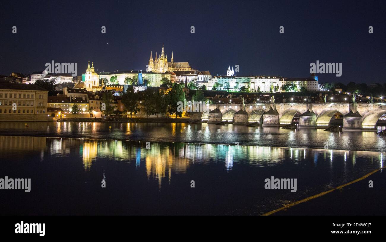 Pargue ponte carlo e il castello di praga di notte riflessioni fiume Foto Stock