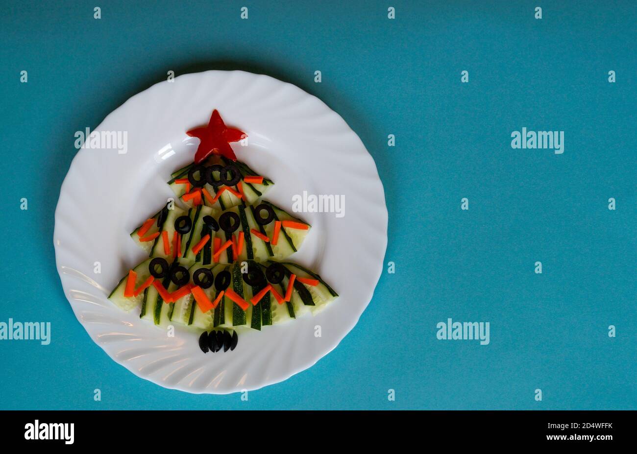 Cibo di Capodanno. Albero di Natale fatto di cibo su sfondo blu. Anno nuovo. Idea creativa, concetto di cibo vegetariano e vegano. Albero di Natale fatto di Foto Stock