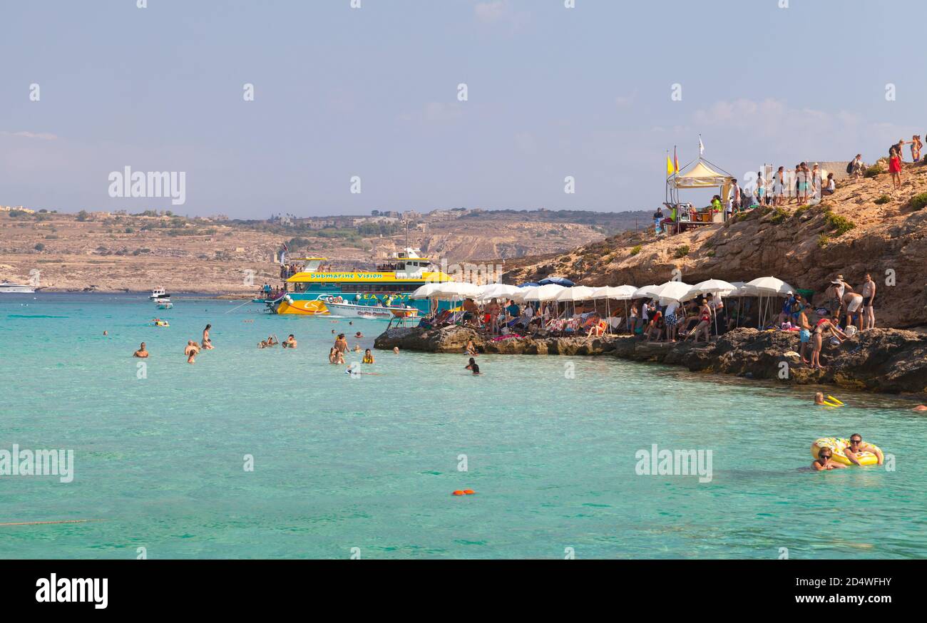 Comino, Malta - 27 agosto 2019: Vista sulla spiaggia della Laguna Blu con turisti rilassanti durante la soleggiata giornata estiva Foto Stock