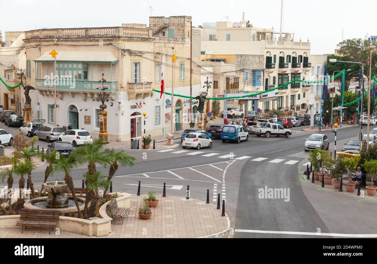 In-Naxxxar, Malta - 31 agosto 2019: Vista sulla strada di Triq tal-Labor con fontana di strada, auto parcheggiate e gente comune e la strada Foto Stock