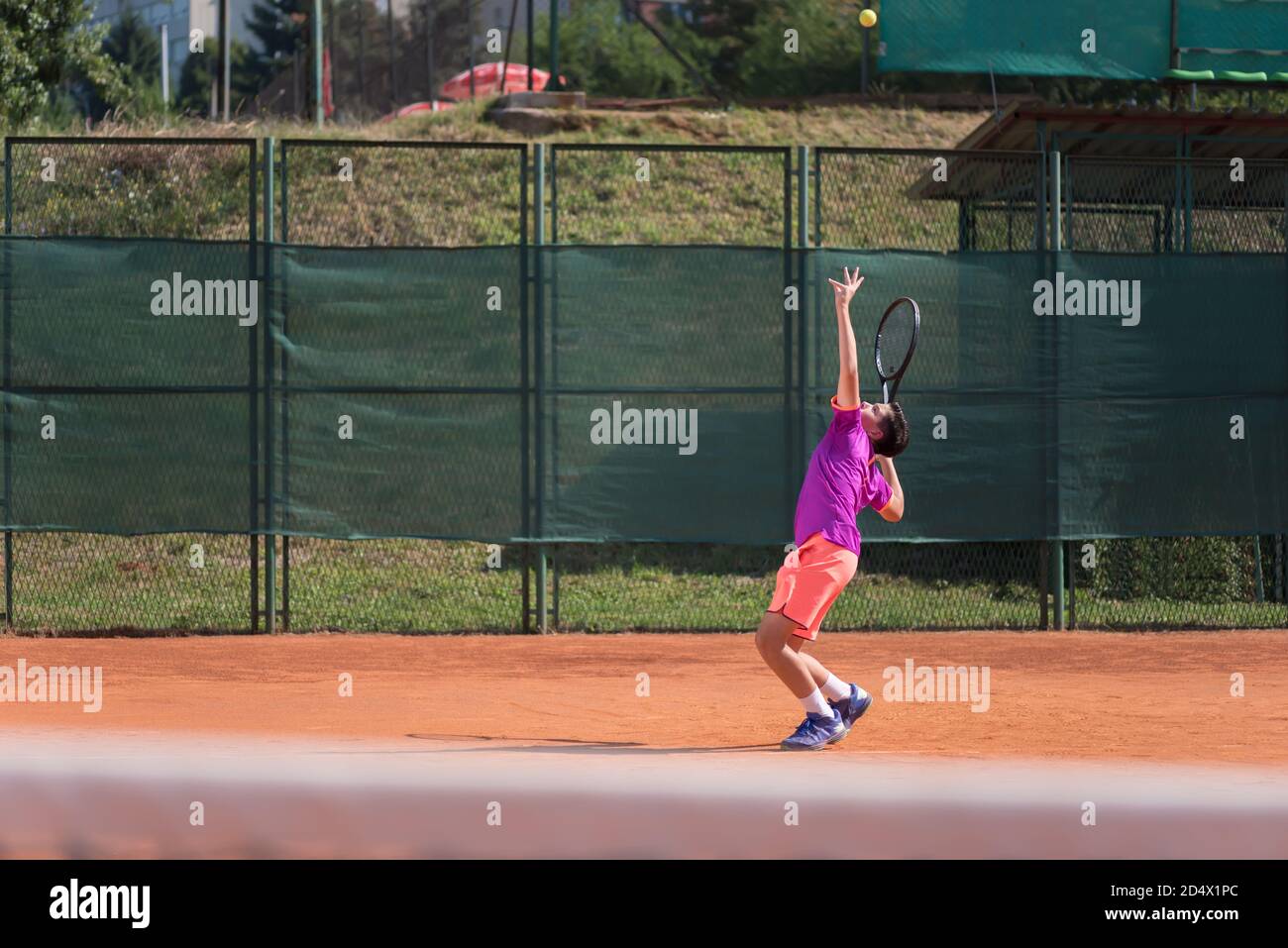 Giovane tennista che serve la palla Foto Stock