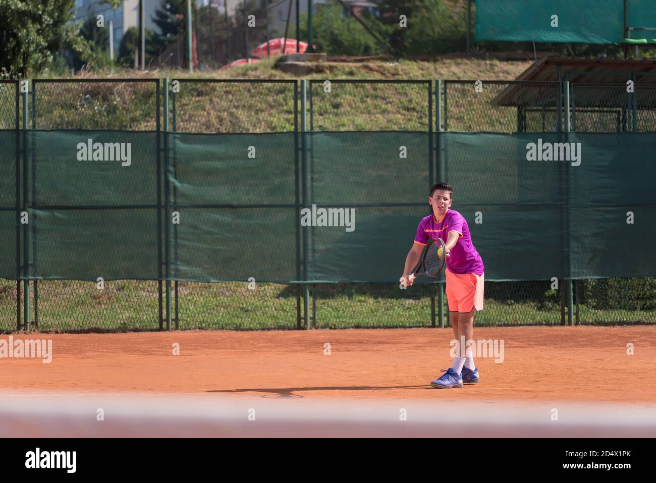 Giovane tennista che serve la palla Foto Stock