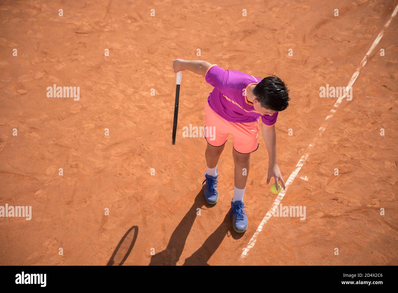 Il giovane tennista si prepara a servire la palla Foto Stock