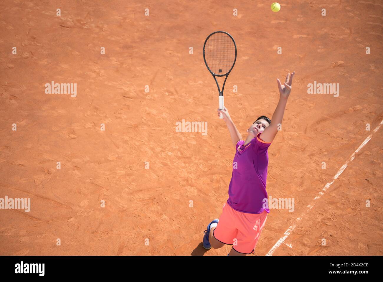 Giovane tennista che serve la palla Foto Stock