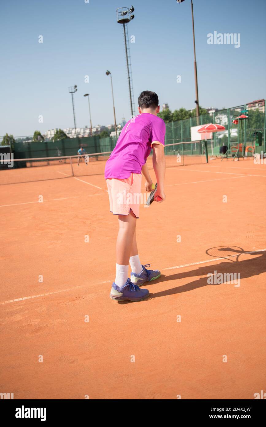 Il giovane tennista si prepara a servire la palla Foto Stock