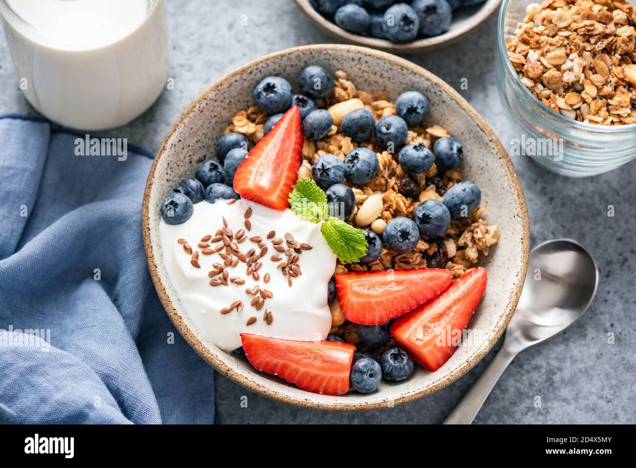 Recipiente di granola con yogurt e frutti di bosco in un recipiente. Cibo sano per la colazione Foto Stock