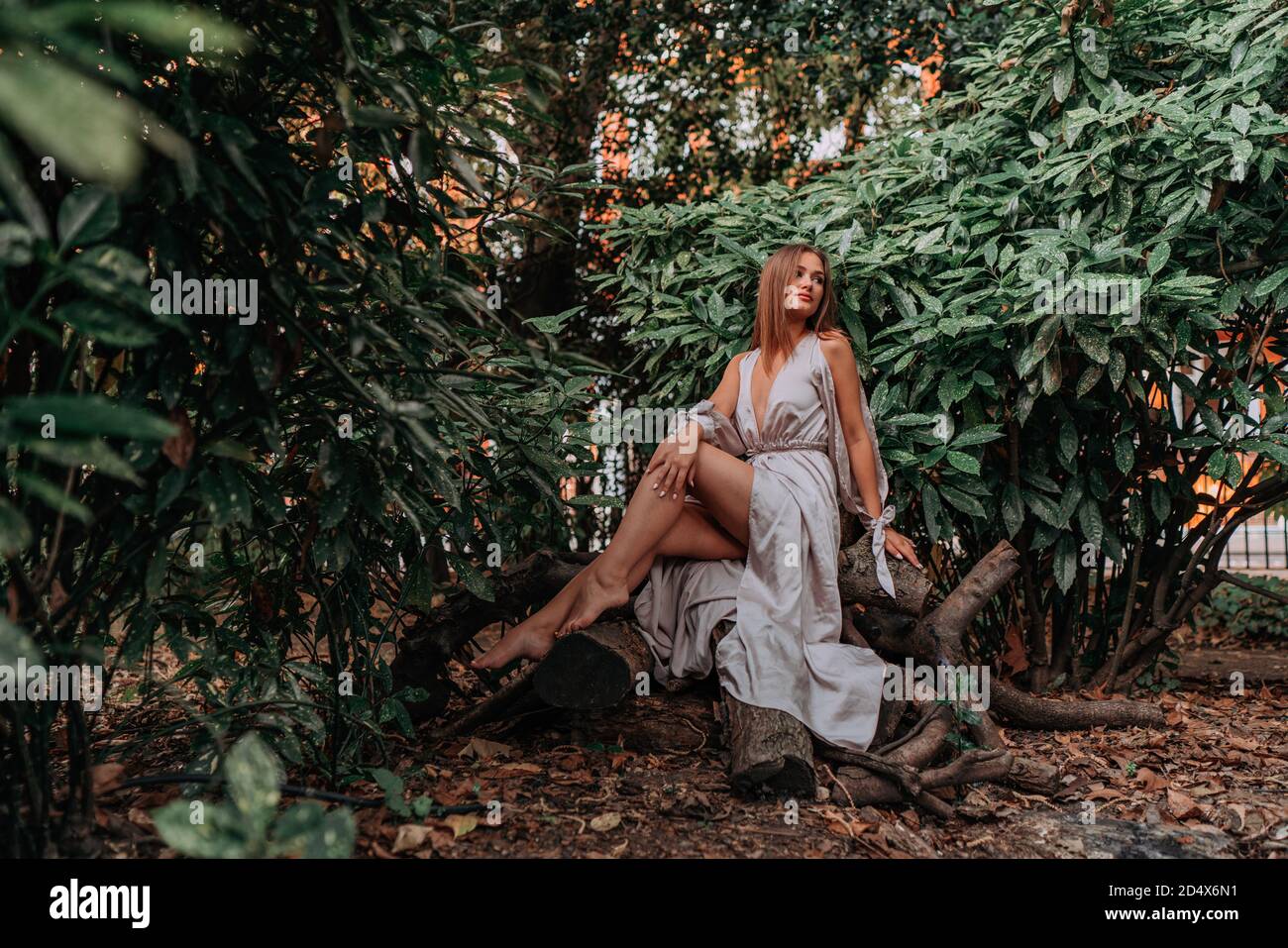 Ritratto di una giovane donna in posa nel parco cittadino Foto Stock