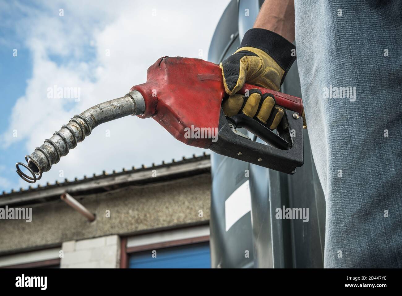 Trasporti e tema automobilistico. Gli uomini caucasici nei suoi 40 anni tengono in mano l'ugello della pompa diesel e si preparano per la procedura di rifornimento di semi-camion. Foto Stock