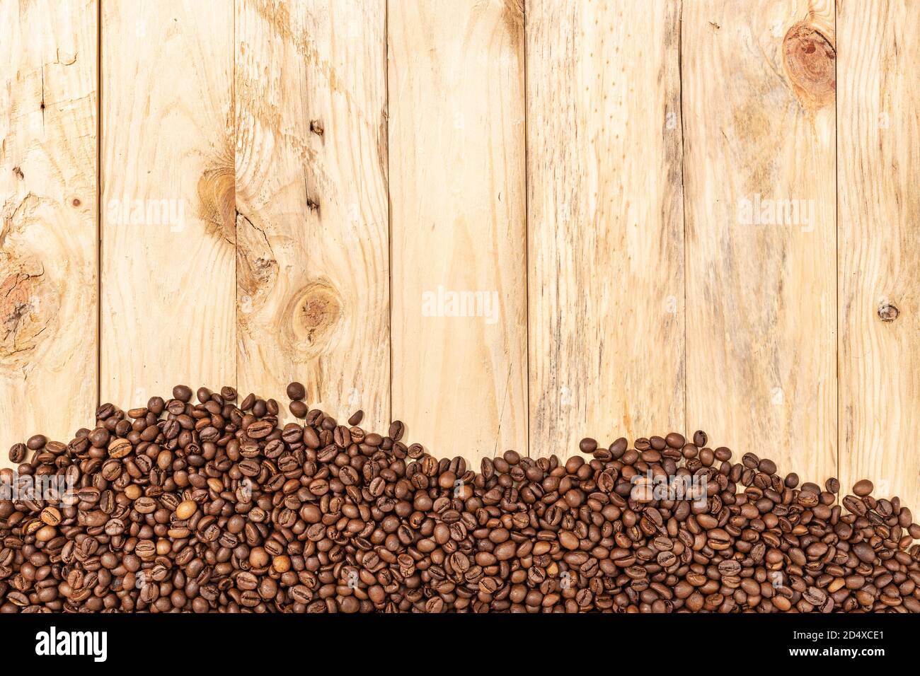 Fagioli arrostiti su tavole di legno di sfondo. Carta da parati da caffè. Spazio di copia. Vista dall'alto Foto Stock