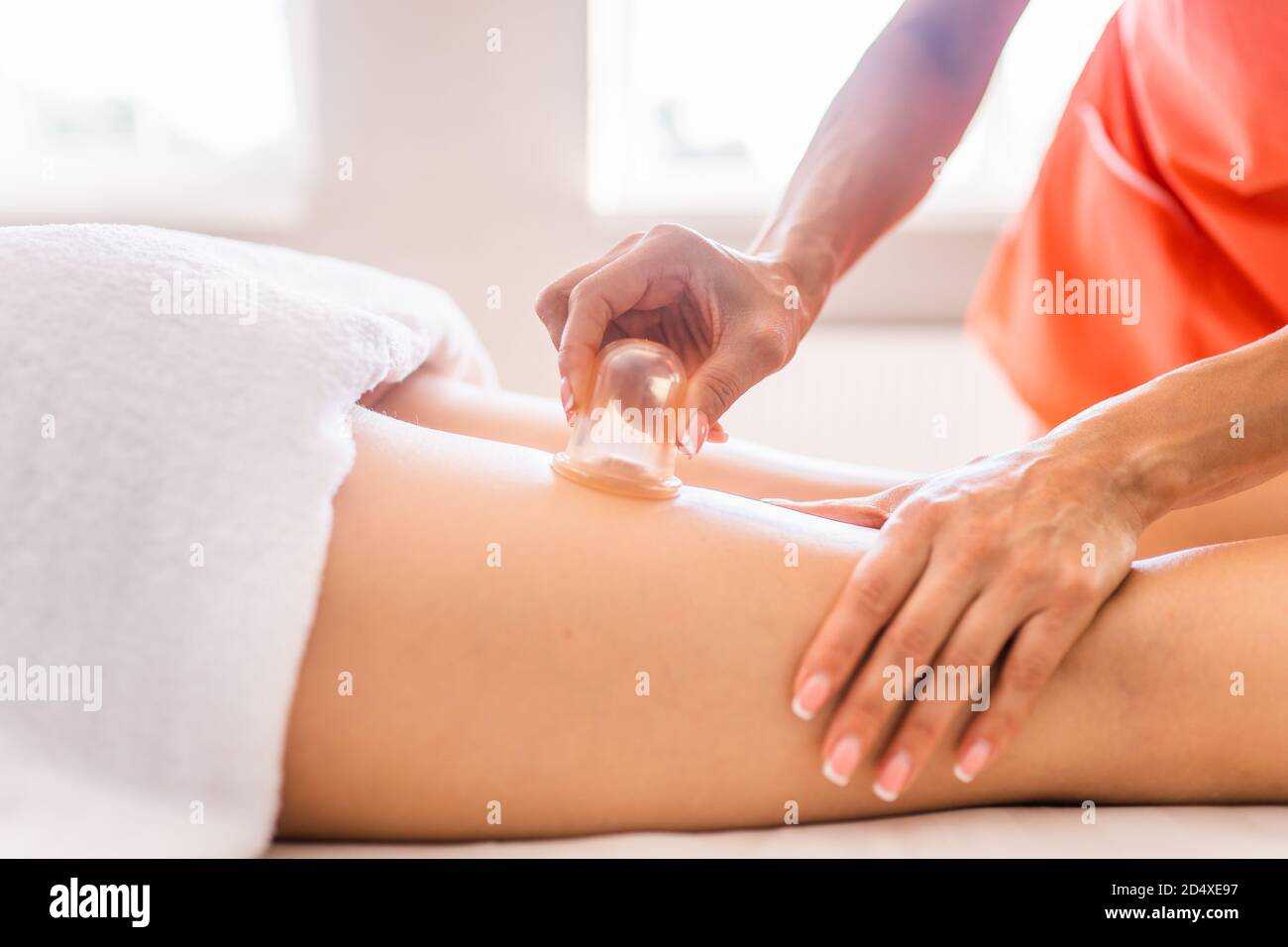 Massaggiatore fare massaggio con vasi di cellulite sulla natiche e cosce  del paziente. Trattamento del peso in eccesso, anticellulite, cura della  pelle Foto stock - Alamy