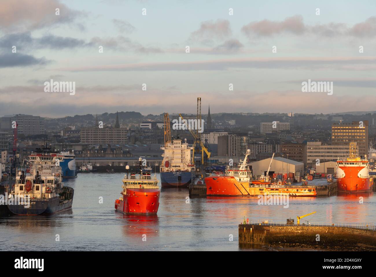 Il sole della mattina presto mette in evidenza le navi di supporto e le barche di rifornimento Attraccato nel porto di Aberdeen sulla costa nord-orientale di Scozia Foto Stock