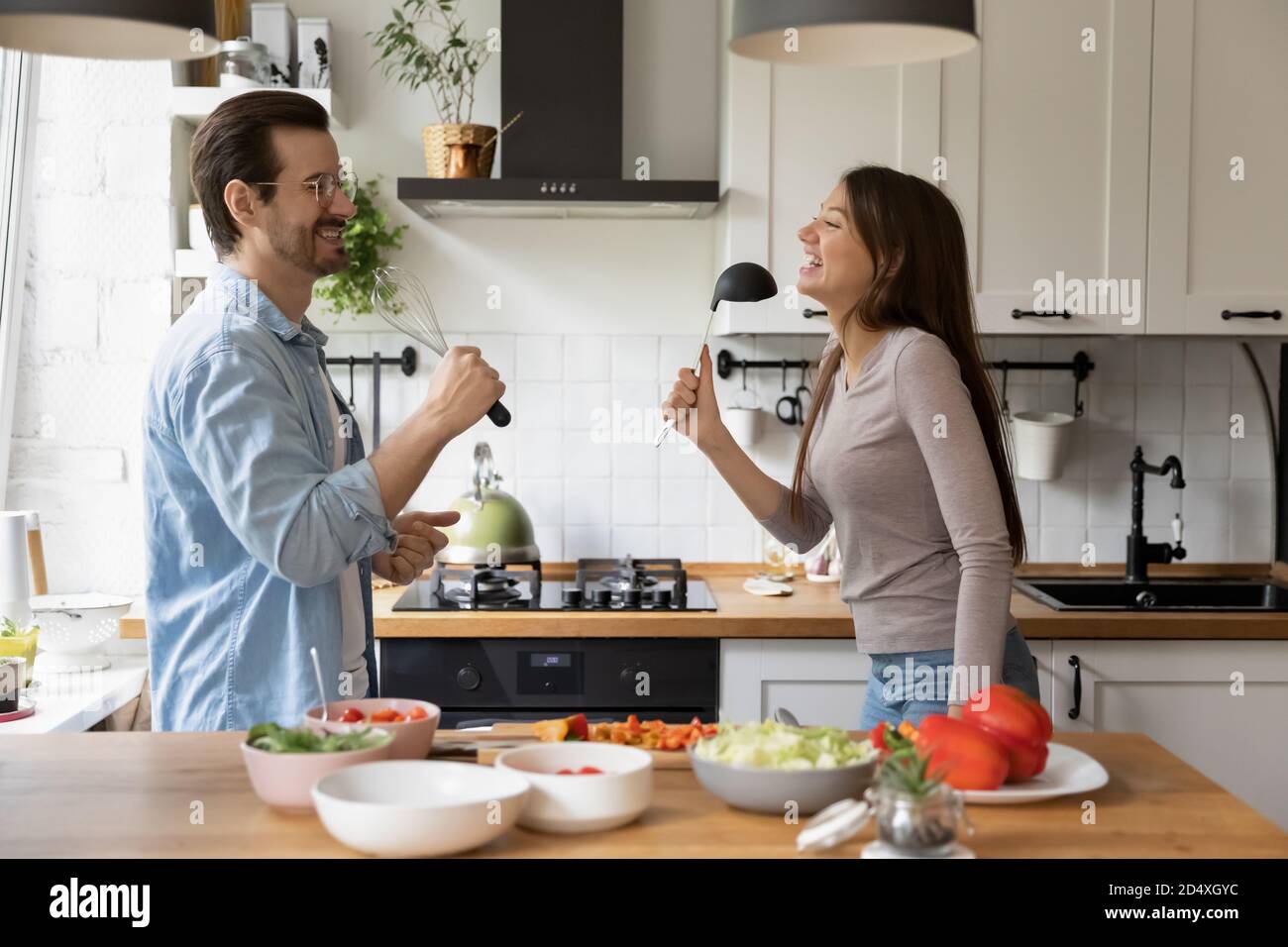 Divertente coppia di famiglia che si diverte in cucina. Foto Stock