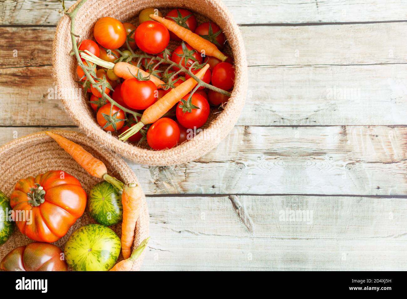 Cestino con una varietà di carote e pomodori per bambini, tra cui ciliegia, Heirloom e Zebra. Foto Stock