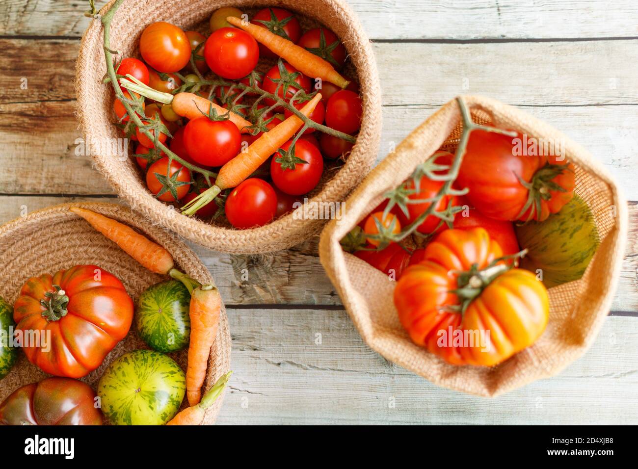 Cestino con una varietà di carote e pomodori per bambini, tra cui ciliegia, Heirloom e Zebra. Foto Stock