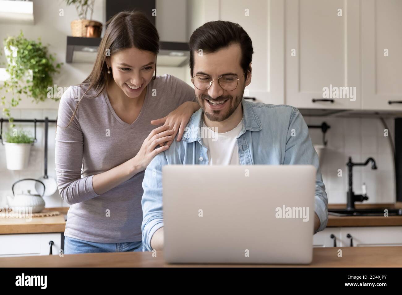 Felice giovane coppia di famiglia amorevole guardando lo schermo del laptop. Foto Stock