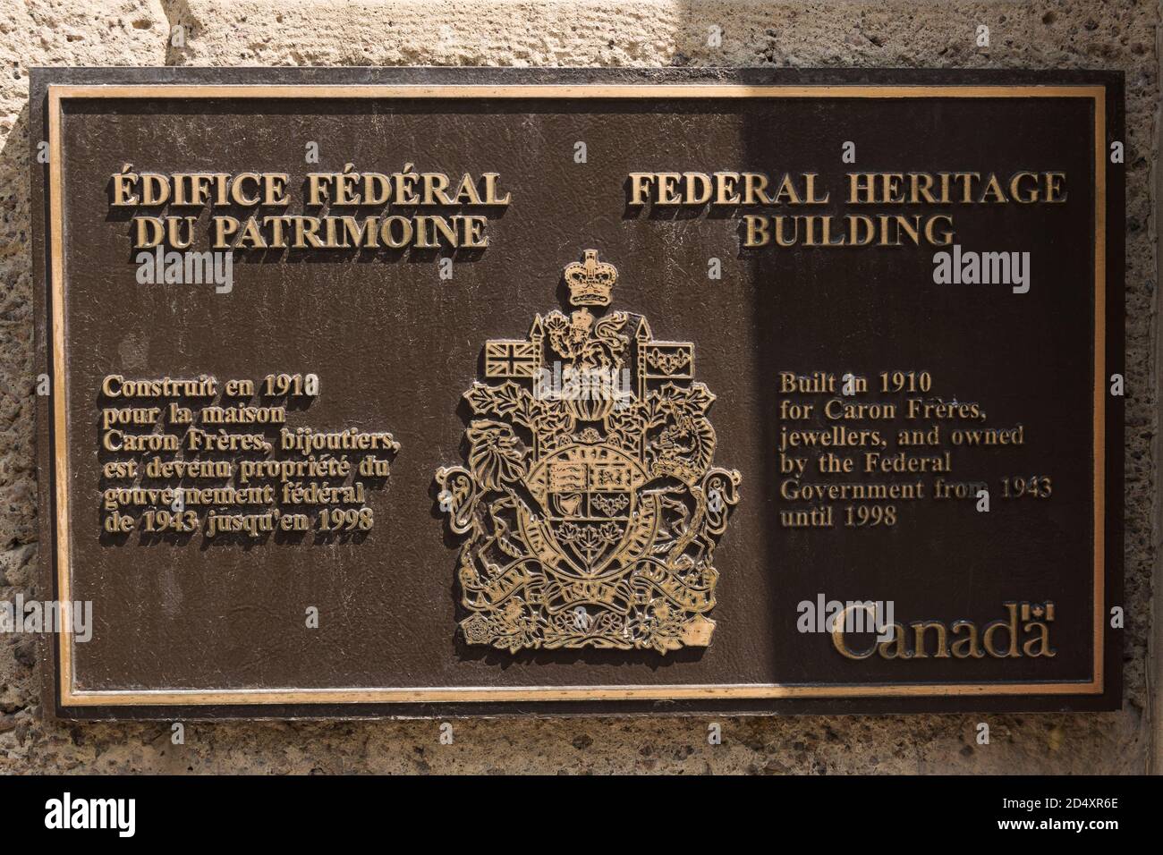 Targa di informazioni storiche sul muro del vecchio ristrutturato 1910 in pietra tan multistoried condominio e spazio ufficio residenziale patrimonio edificio facciata, Montreal Foto Stock