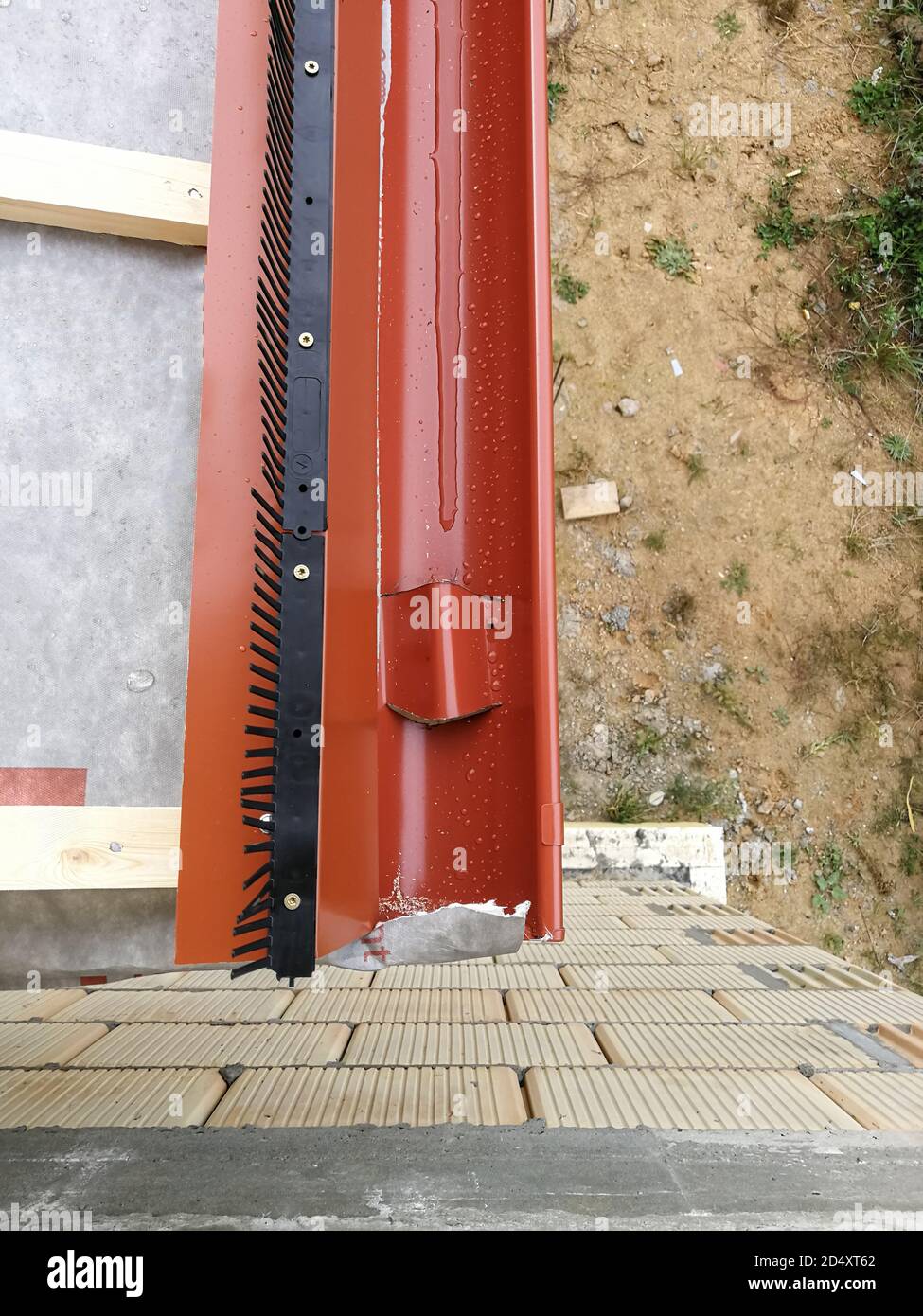 Grondaia con tubo discendente per la raccolta di acqua piovana in casa in costruzione in cantiere Foto Stock