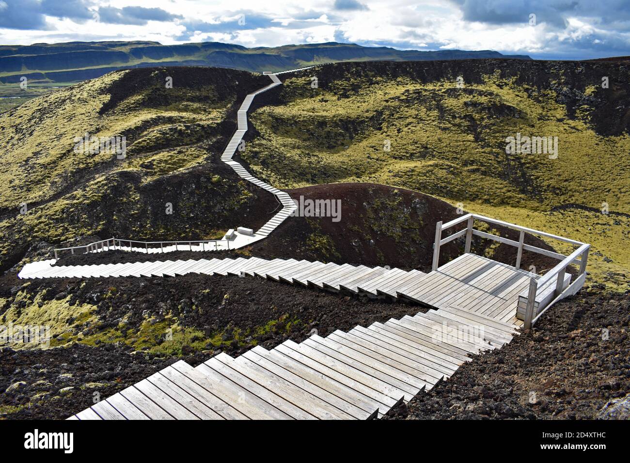Una passerella in legno scende intorno al bordo del Cratere del Vulcano Grabrok nella Valle di Nordurardalur, in Islanda occidentale. Foto Stock