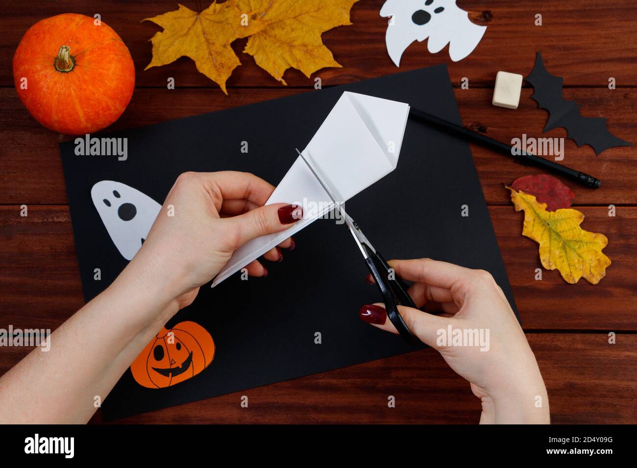 Fai da te di Halloween. Istruzioni dettagliate per tagliare un nastro di ragno dalla carta per le vacanze. Foto Stock