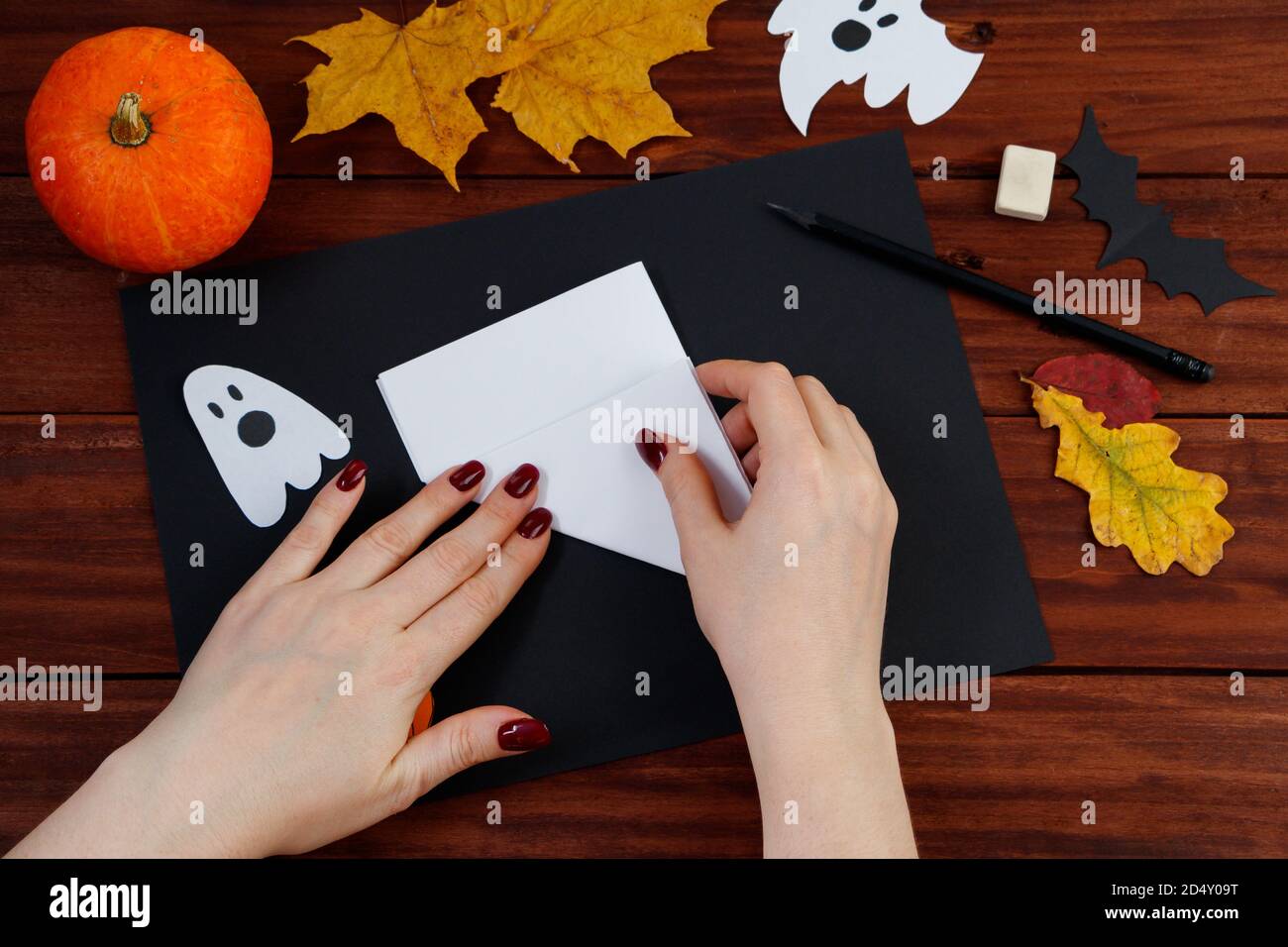 Fai da te di Halloween. Istruzioni dettagliate per tagliare un nastro di ragno dalla carta per le vacanze. Foto Stock