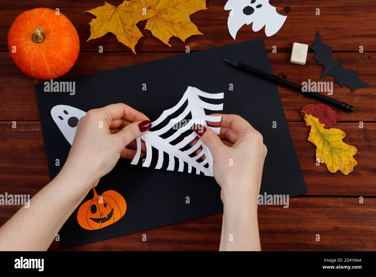 Fai da te di Halloween. Istruzioni dettagliate per tagliare un nastro di ragno dalla carta per le vacanze. Foto Stock